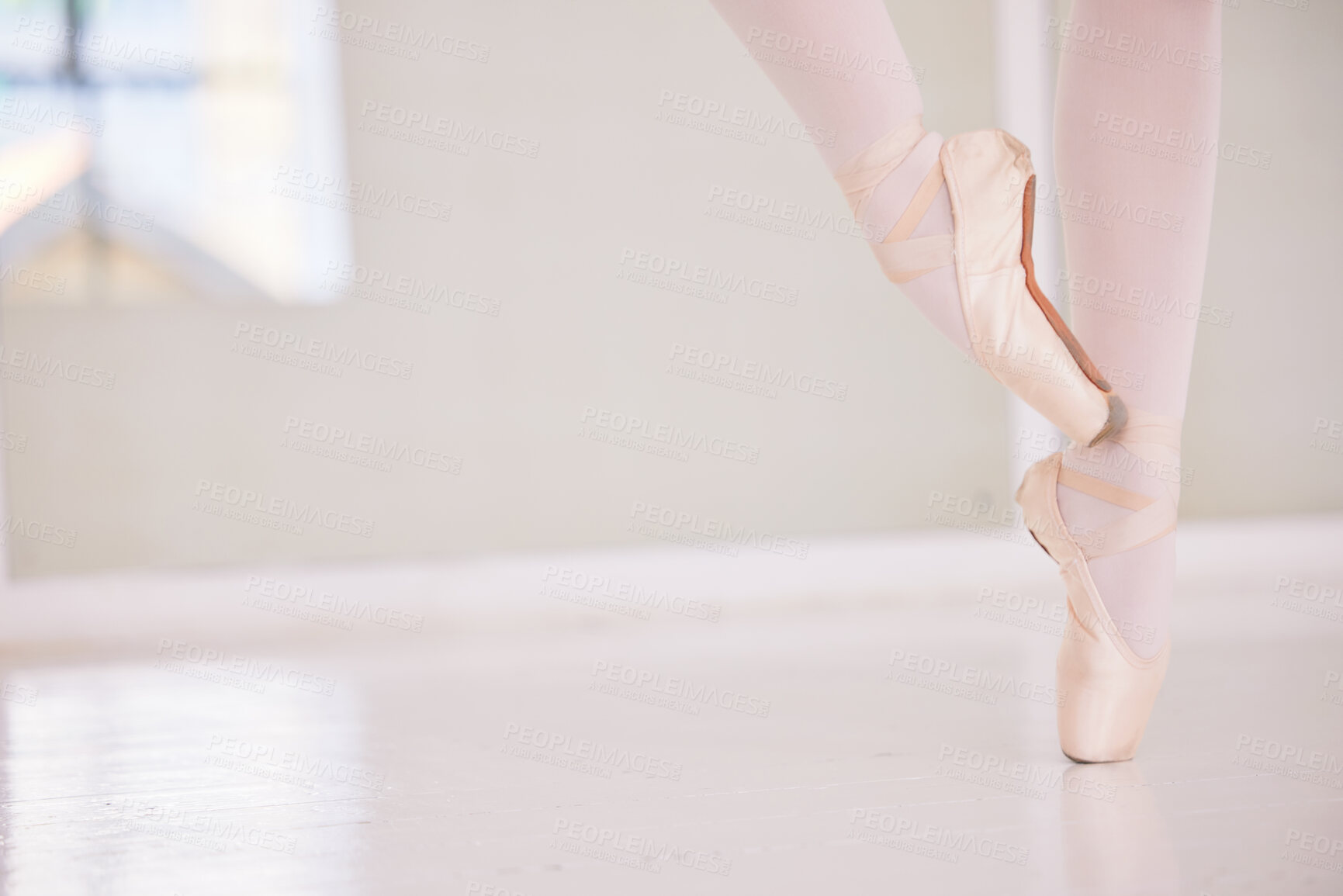 Buy stock photo Ballet feet or legs on the tiptoe dancing or practicing in a dance studio or class with copy space. Closeup of an elegant dancer or ballerina in pointe shoes preparing for a performance