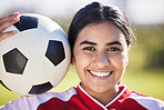 Training, football and portrait of a sporty woman face and soccer ball, enjoying sport and a healthy lifestyle at a field or park. Happy player having fun with fitness, being active and carefree