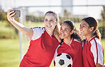 Selfie, soccer and sports team smiling and feeling happy while posing for a social media picture. Diverse and young girls standing together on a football field. Friends and teammates enjoying a match