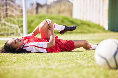 Buy stock photo Injured, pain or injury of a female soccer player lying on a field holding her knee during a match. Hurt woman footballer  with a painful leg on the ground in agony having a bad day on the pitch