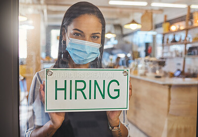 Buy stock photo Business woman advertising a hiring sign in her startup coffee shop door. Entrepreneur, business owner or manager wearing a mask searching for employee or workers in a cafe during covid pandemic

