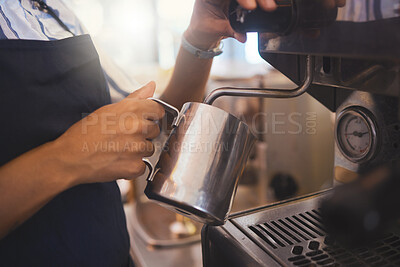 Buy stock photo Coffee shop, barista and waitress working in a cafe and pouring a fresh drink in a restaurant while in an apron. Closeup of a hand foaming or steaming milk in the service and hospitality industry.