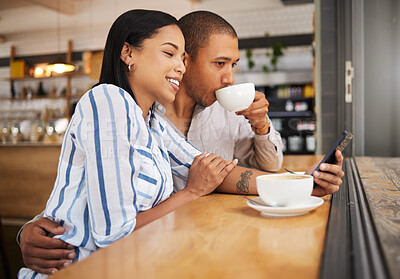 Buy stock photo Couple using social media on a phone and drinking tea in a coffee shop together. Happy man and woman with 5g mobile smartphone texting and searching on an online app and enjoy a date at a cafe