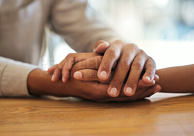 Buy stock photo Support, unity and trust by a couple feeling grief due to cancer holding hands together on a table. Closeup of an African American man and woman bonding and connecting due to compassion and love
