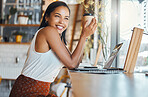 Happy woman relaxing in a coffee shop with a smile and thinking. Female enjoying relaxed day alone working on a laptop while browsing the internet and social media and having an startup project idea