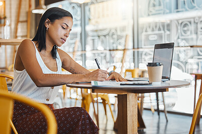 Buy stock photo Student writing, taking notes or doing a project assignment in cafe or restaurant using laptop and notebook. Young woman taking an online education class or doing study work, learning in coffee shop.