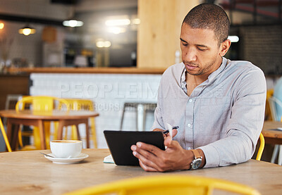 Buy stock photo Serious freelance business man working in a coffee shop doing remote work for his startup. Young male entrepreneur using a tablet planning growth strategy in a cafe and writing notes