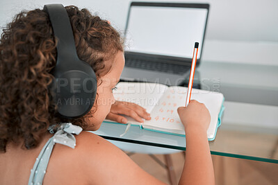 Buy stock photo Home, school and education of a girl writing, learning and working or study online on a laptop. Child, internet and student using technology for elearning at the house while listening to podcast.