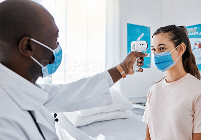 Buy stock photo Covid temperature testing at the hospital by a doctor of a female patient wearing masks and using an infrared thermometer. Medical professional checking a female for covid19 virus or infection