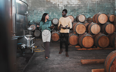 Buy stock photo Wine cellar, warehouse and winery worker teaching a man about wine while he is writing notes. Winemaker walking in a distillery with wooden barrels and agriculture machines while consulting a partner