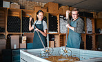 Winemakers mixing and shaking grapes during the wine making process inside of a distillery. Cellar owners use a steel tool to press the juice out of fruit before fermentation to make alcohol