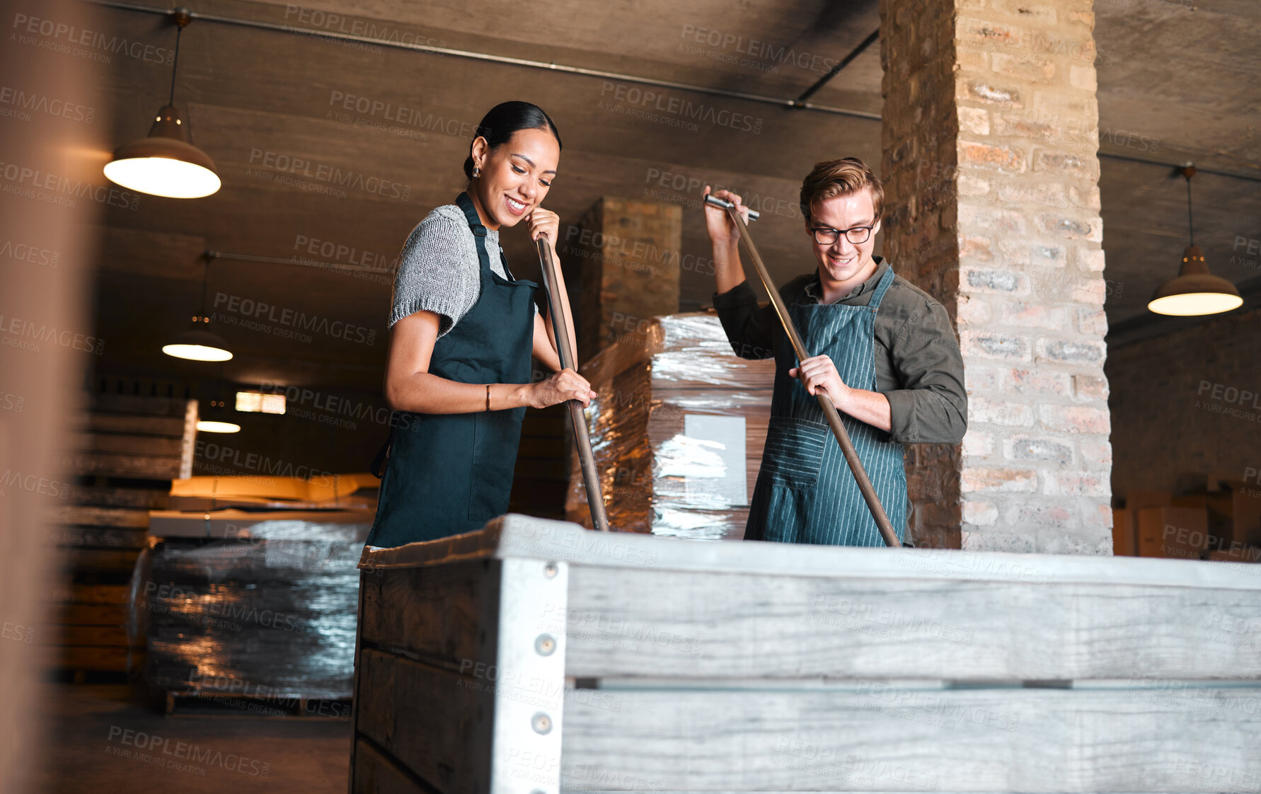 Buy stock photo Wine making, production and cellar workers holding press tool to crush, blend and stir open tank for alcohol process. Vintner, factory and winery industry with distillery and manufacturing warehouse