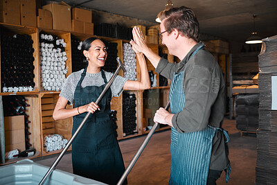 Buy stock photo Success, partnership and collaboration business partner high five while working together in a wine distillery. Winemaker workers excited and having fun pressing grapes in the wine industry together