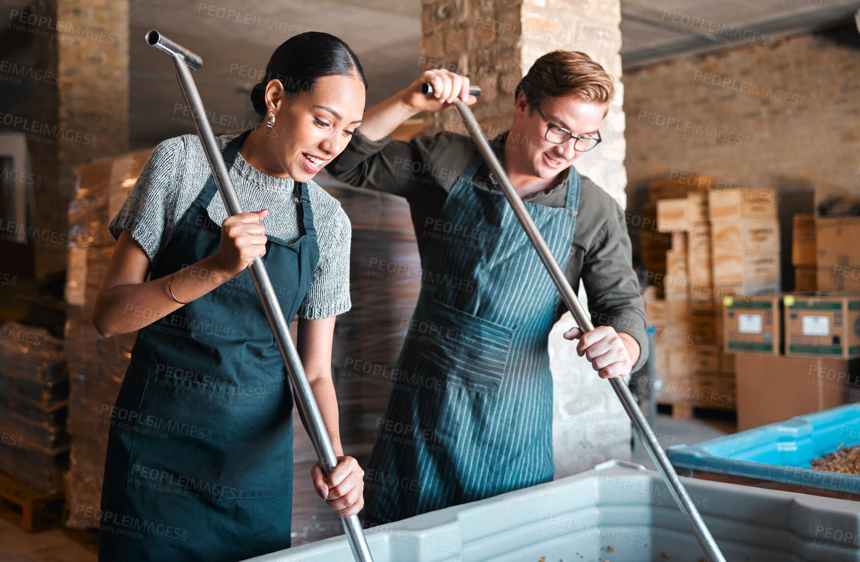 Buy stock photo Cellar workers, making wine and mixing open tank with stirring, pressing and crushing tool for alcohol production. Happy staff and merchants in factory distillery, winery and manufacturing warehouse