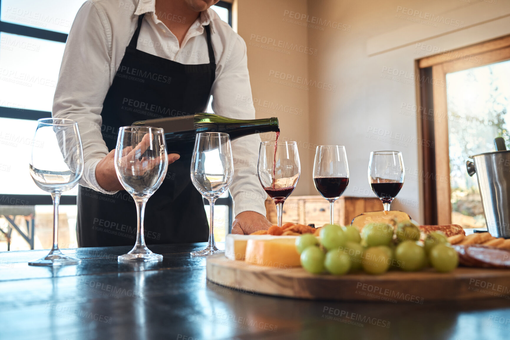 Buy stock photo Hospitality, industry, and luxury wine service with waiter pouring in glasses, prepare for wine tasting at restaurant. Professional sommelier setting up for fine dining experience with alcohol 