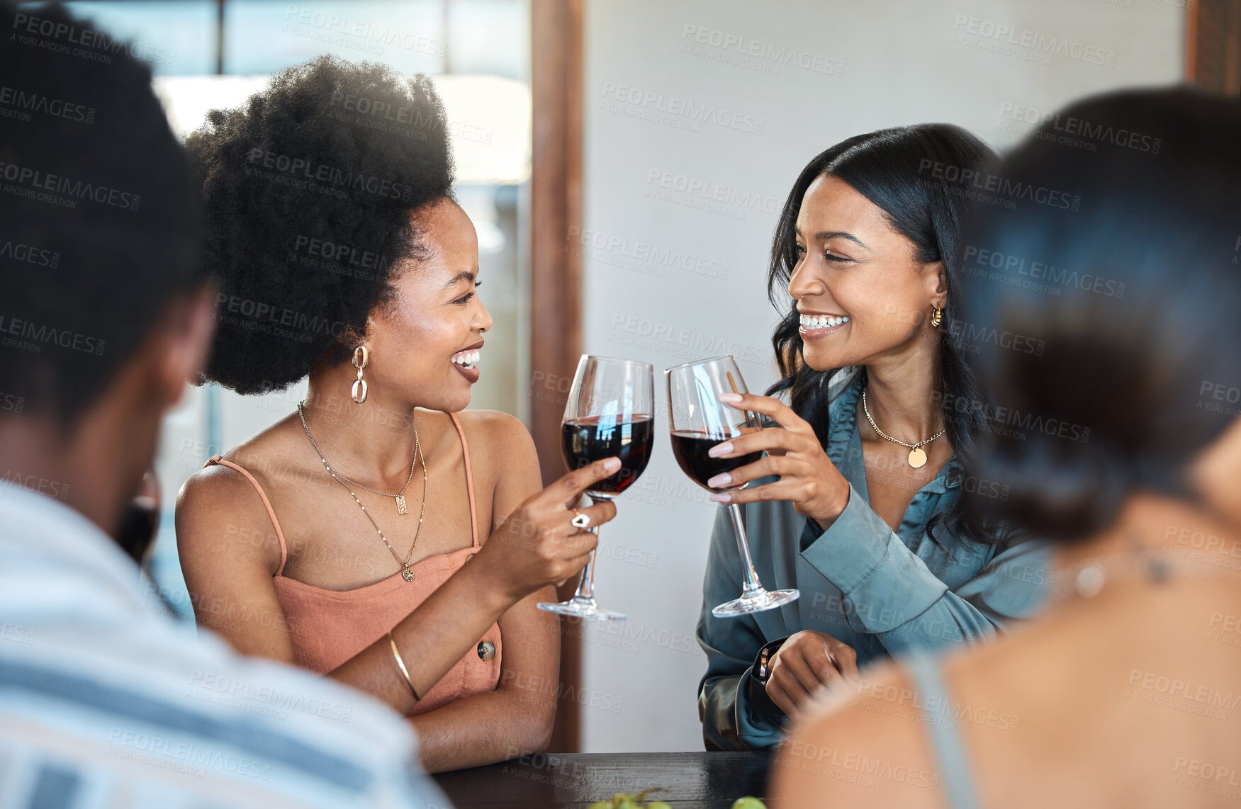 Buy stock photo Friends having fun and drinking wine, toasting, bonding and celebrating at an event or party. Diverse friends cheers and laughing, enjoying free time, dining experience and wine tasting gathering