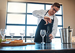 Bartender with red wine tasting at luxury restaurant or vineyard and vintage alcohol bottle and glasses for fine dining, culinary or hospitality industry. Sommelier service with quality alcohol drink