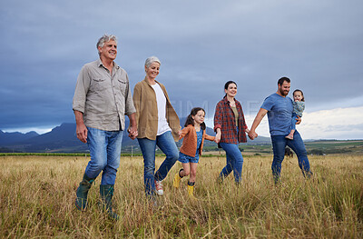 Buy stock photo Big happy family walking on field, meadow and countryside in nature to relax, bond and holding hands in love, trust and support. Generation of grandparents, parents and kids having fun outside
