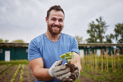 Buy stock photo Happy farming worker with a plant on an agriculture farm with a smile. Farmer advertising sustainability, growth and ecology on a green field or land  in a nature eco friendly environment countryside