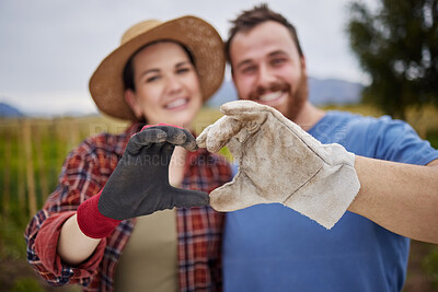 Buy stock photo Farmer or gardener couple showing love heart sign with their hands outdoors on an organic or sustainable farm. Happy and excited activists support sustainability or organic farming