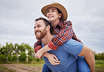 Playful, agriculture farmer couple having fun on a farm, countryside or nature environment enjoying rustic, sustainable living lifestyle. Happy, caring and in love husband giving wife piggyback ride