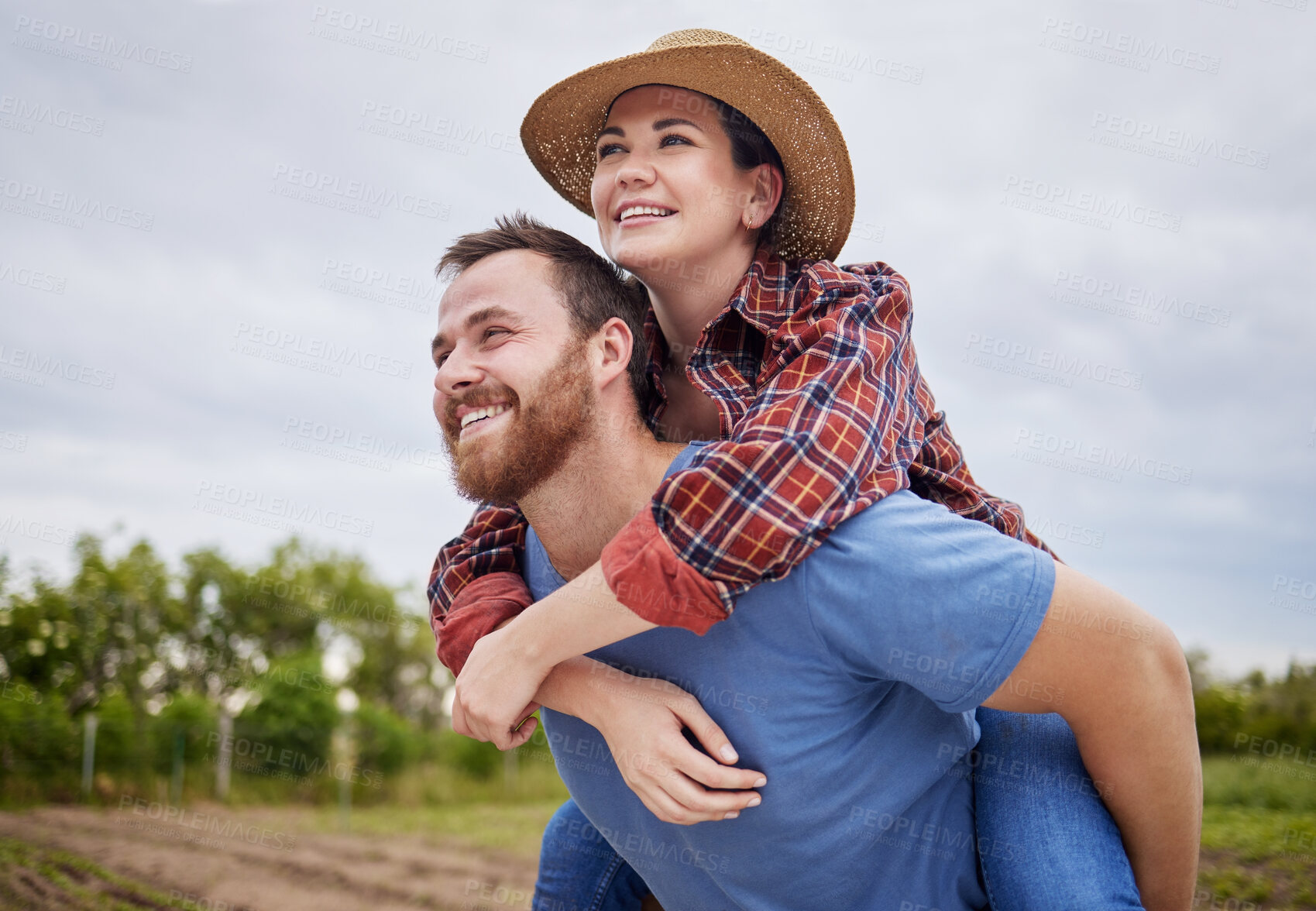 Buy stock photo Playful, agriculture farmer couple having fun on a farm, countryside or nature environment enjoying rustic, sustainable living lifestyle. Happy, caring and in love husband giving wife piggyback ride