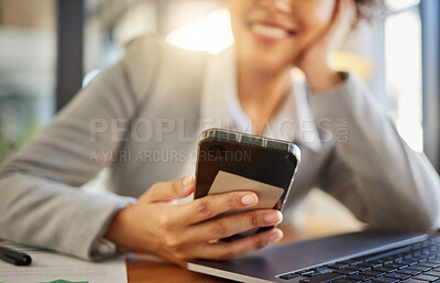 Buy stock photo Employee texting on a phone while working on a laptop, smiling and relaxing in a modern office. Closeup of a female reading social media, text message or chatting online, excited about dating app