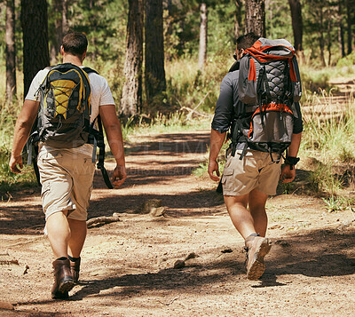 Buy stock photo Backpacker friends explore nature while hiking in a forest together, being active and bonding outdoors. Active men on a path in the woods, enjoying a physical challenge while on trekking adventure