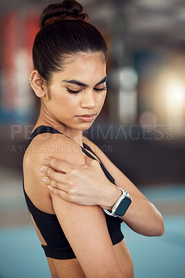 Buy stock photo Injury, hurt and shoulder pain for a female athlete holding her painful arm at the gym. Active, fit and athletic woman suffering from muscle inflammation due to an exercise or workout