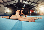 Sports woman stretching on the floor in yoga splits in a gym. Young fitness girl or athlete legs in training, workout exercise or cardio with motivation, wellness and commitment for a competition