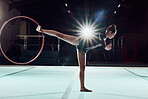Gymnastics, dance and sport with a woman gymnast performance on a floor with a hoop or ring. Olympics, rhythm and agile dancer performing a routine, recital or training for a competitive event