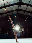 Performance, woman and balance body for competition practice for gymnastics. Stretching legs, flexible and competitive girl with focus. Hula hoop ring and sports person pose with flare light effect. 