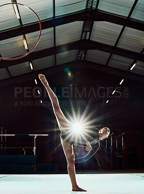 Buy stock photo Girl, art stage and body performance for gymnastic balance and competition practice studio. Acrobat sports and dancer woman with hula hoop ring stretching legs in front of flare light effect.