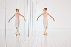 Fitness, exercise and the art of ballet, young dancer watching herself in a mirror. Happy, confident and learning to love dance and dancing the lifestyle. A ballerina girl training alone in a studio.