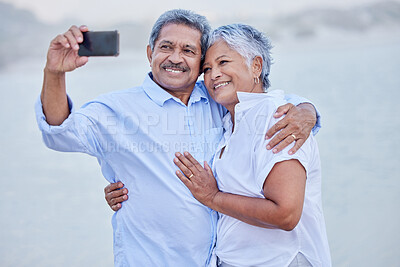Buy stock photo Senior couple taking selfie on phone with smile for social media app online with 5g network while on a date together. Love, marriage retirement man and woman on beach sand mock up white background