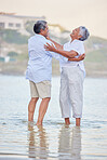 Beach dance, senior couple and laughing man and woman standing in sea or ocean water and hugging at sunset. Happy, smile or bonding for marriage anniversary or love while dancing in nature with trust