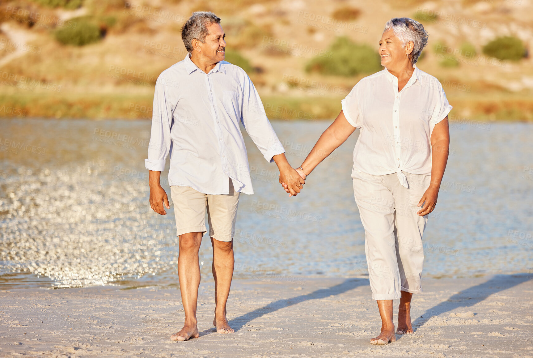 Buy stock photo Love, walking and senior couple on a beach lake together for calm, relax and romantic ocean, water or sea date. Elderly happy people, man and woman smile while living pension and retirement lifestyle