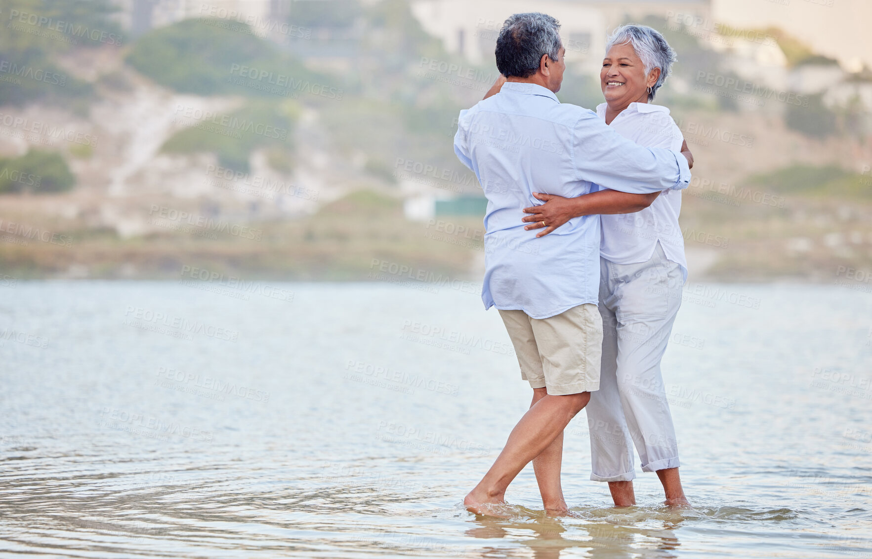 Buy stock photo Landscape, beach and dance of a senior couple smiling and dancing in the sea or ocean water and hugging at sunset. Happy, smile or bonding of an old man and woman dancing in nature for marriage.
