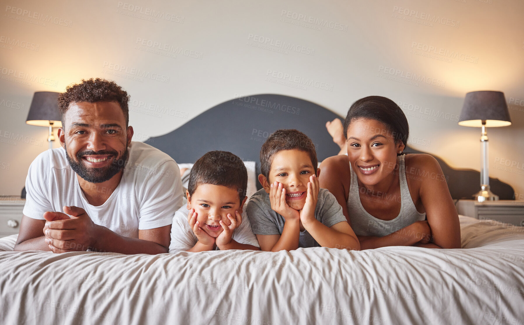 Buy stock photo Portrait of parents and kids lying on bed in the morning with a smile. Playful, fun, mom and dad playing indoors showing growth, child development, happiness and childhood innocence from little boys