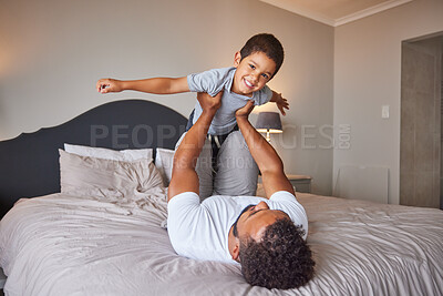 Buy stock photo Smile, love and happy father and son family time playing in bedroom bed lifting him like airplane or superhero. Loving dad, man or single parent bonding with cheerful kid in the morning at home.