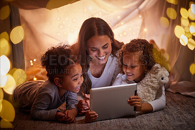 Buy stock photo Mother and children live streaming movies on tablet or digital kids app in a tent camping at night and bokeh lights. Care, love mom reading ebook to happy girl or online games with home wifi in dark