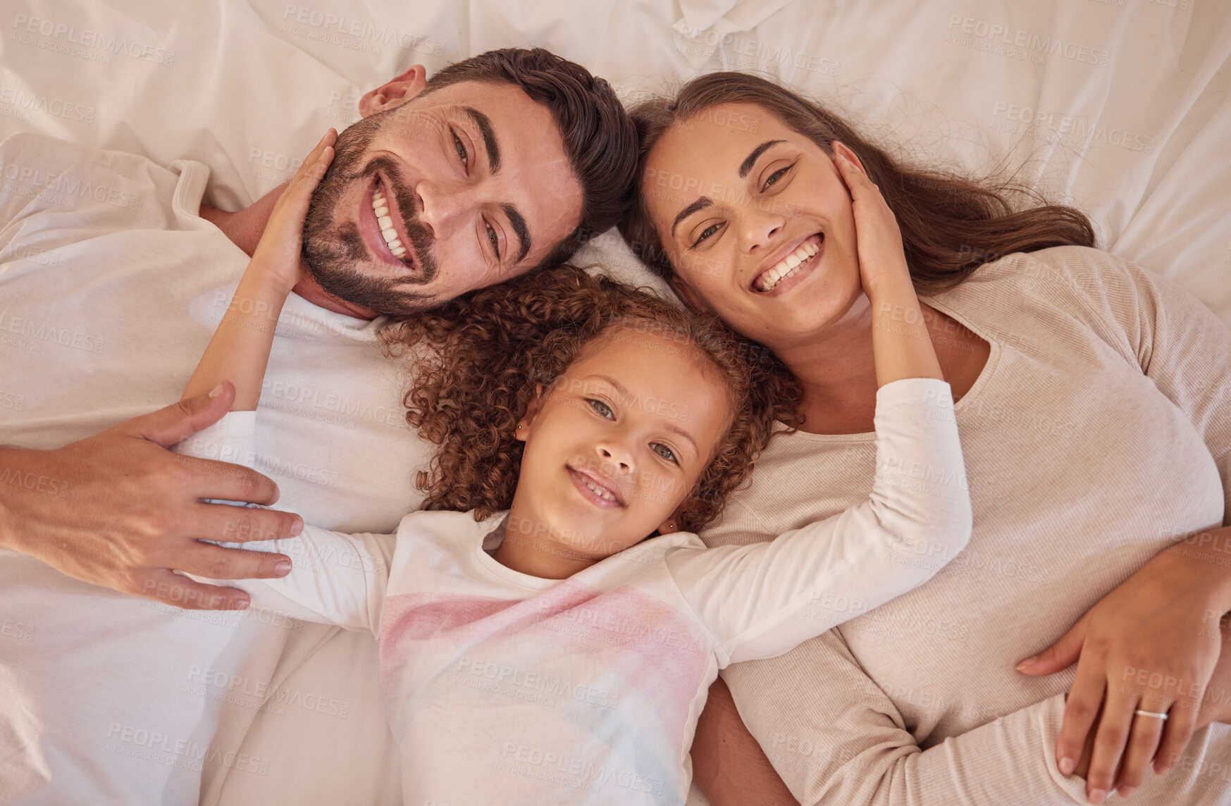 Buy stock photo Portrait of happy love parents and daughter with smile in bed while relax in the morning. Family or mom, dad and child lying in bedroom having playful fun and bonding with happiness at home together