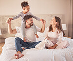 Family happy, smile and relax while play in bed at home together in the morning. Mother, father and girl or daughter laughing and playful fun with love in the bedroom at home while bonding together