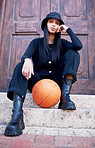 Basketball, fashion and model influencer of a woman posing on steps in an urban city with fashionable style. Female portrait of trendy, stylish and cool person in sports promotion for ball game.