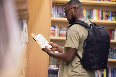 Buy stock photo Education student with book in a library at university, college or school reading or doing research. Scholarship, learning and study knowledge and black man with print books on shelf and backpack