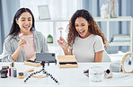 Happy women recording a video tutorial with together for online beauty blog or vlog using her phone at home.  Female content creator or influencer live streaming her cosmetic skills for social media