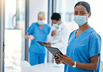 Healthcare, doctor or a nurse on a tablet, consulting in a hospital boardroom. Medical workers meeting to consult, communication online. Covid management and teamwork, doctors wearing surgical masks
