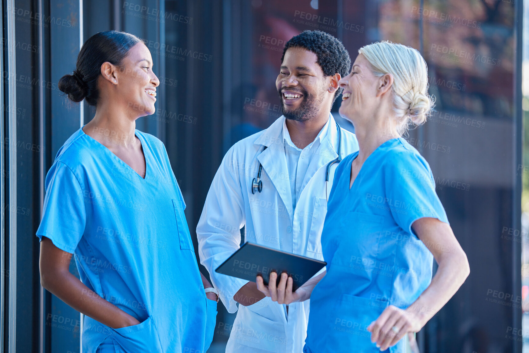 Buy stock photo Diversity, teamwork and healthcare, a team of doctors talking and laughing outside a hospital. A happy black doctor and women nurses having a conversation. A group of medical employees during a break
