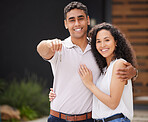 Happy couple with key to new home together, buying property as married man and woman and moving into real estate house. Portrait of people giving hug with love and  homeowner excited about move