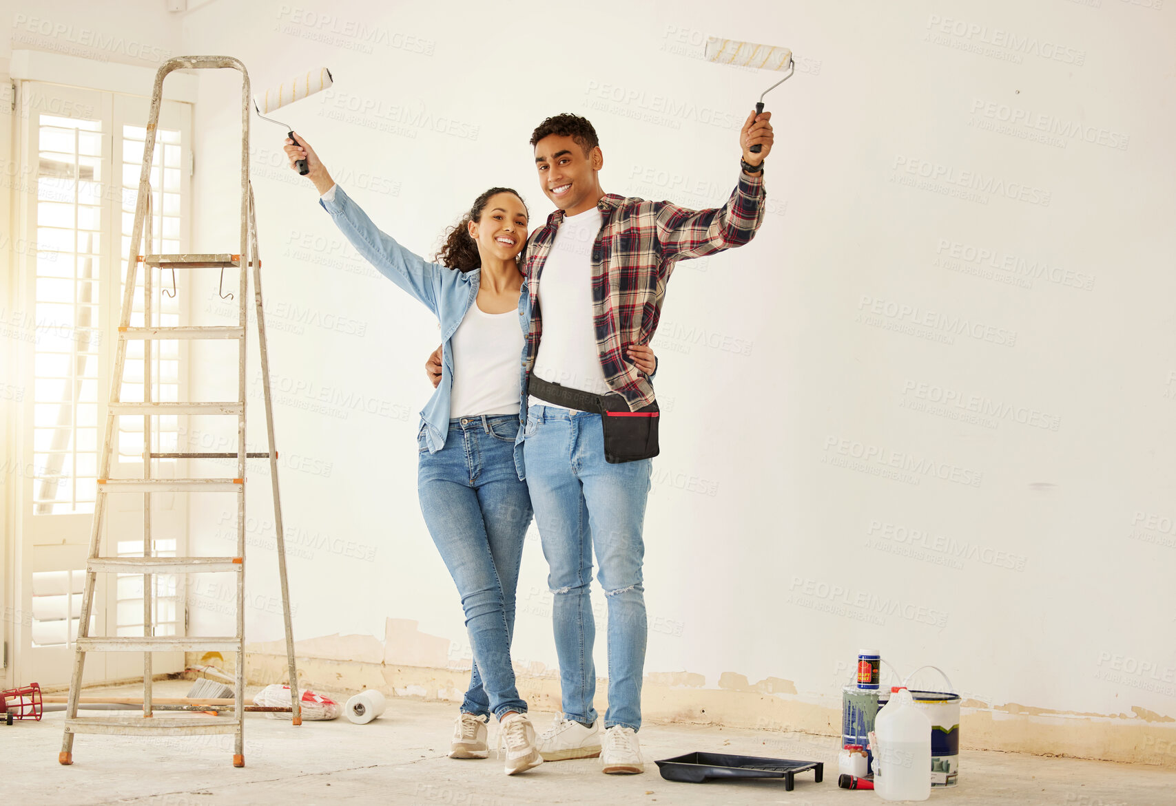 Buy stock photo Portrait of happy couple painting the new living room in a home or apartment. Man and woman with paintbrush to decorate a wall color and renovation the house interior with smile or happiness together